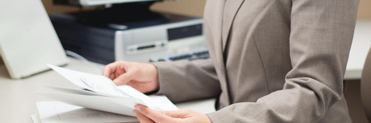 Photo of a business woman doing paperwork at an office. The photo is used as a hero image for Method's free invoice generator guide and tool.